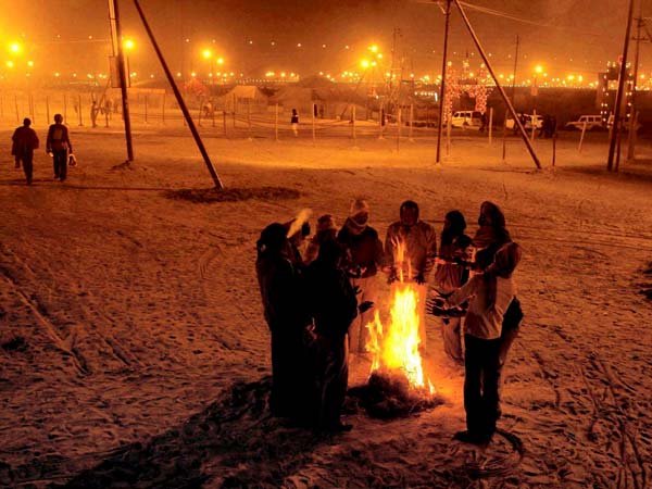 People warm themselves around a fire in Allahabad