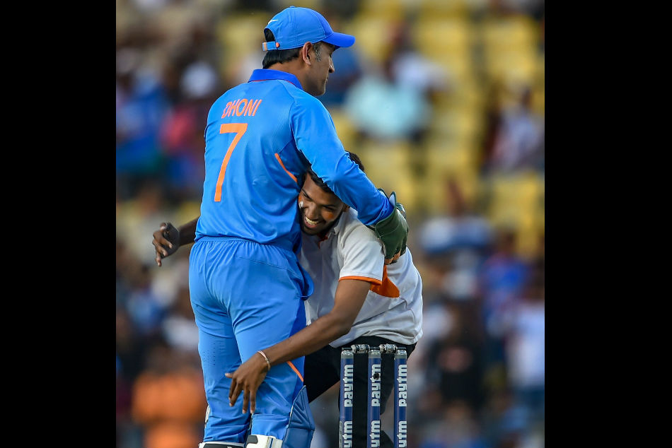 Fan breaks security for embrace from Dhoni